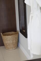 Bathroom corner with a wicker basket and a hanging bathrobe
