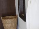 Bathroom corner with a wicker basket and a hanging bathrobe