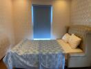 Cozy bedroom with double bed and window with a blind