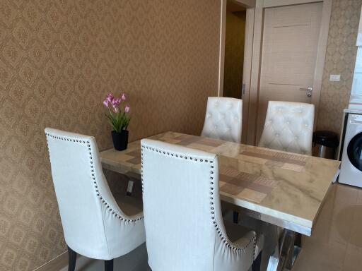 Modern dining area with marble table and white padded chairs