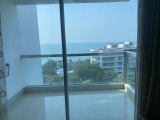 Bedroom with glass door leading to balcony offering ocean view