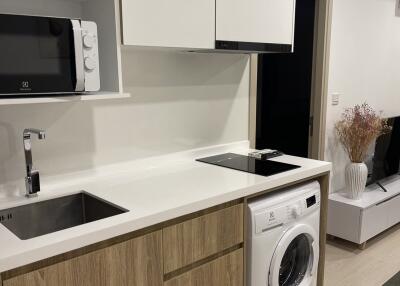 Modern kitchen with wooden cabinets and white countertop, featuring appliances