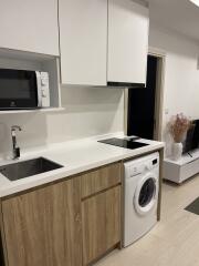 Modern kitchen with wooden cabinets and white countertop, featuring appliances