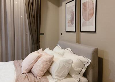 Cozy bedroom with soft lighting, framed artwork, and plush pillows