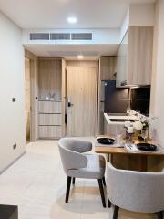 Modern kitchen and dining area with light wood cabinets and contemporary decor