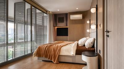 Modern bedroom with large windows and bedside lighting