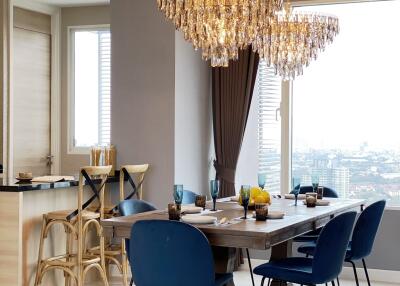 Modern dining area with chandeliers and blue chairs