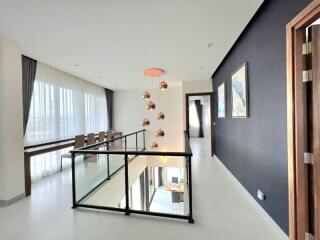 Modern hallway with glass railing and dining area
