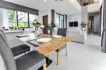 Modern dining area with table set for four next to a living room with a view