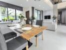 Modern dining area with table set for four next to a living room with a view