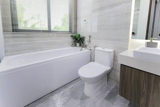 Modern bathroom with bathtub, toilet, and vanity