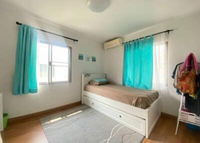 Bright bedroom with twin bed and turquoise curtains
