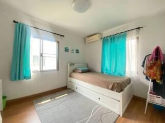 Bright bedroom with twin bed and turquoise curtains