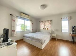 Bright bedroom with wooden floors and white furniture