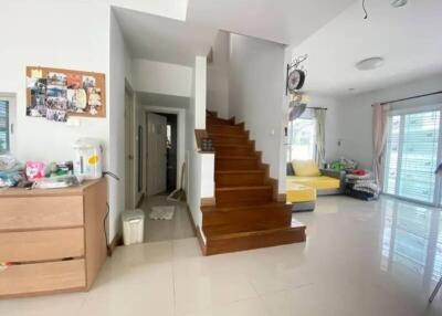 Spacious living area with wooden staircase and natural light