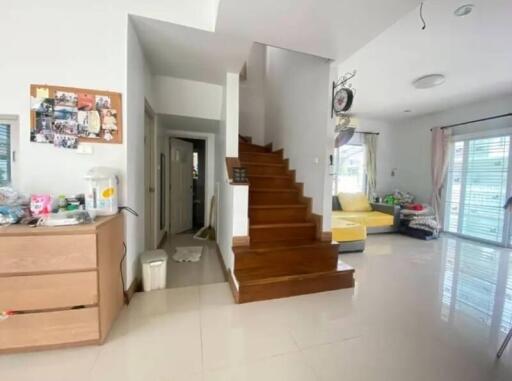 Spacious living area with wooden staircase and natural light