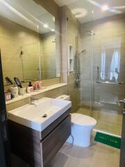 Modern bathroom with walk-in shower, vanity, and toilet.