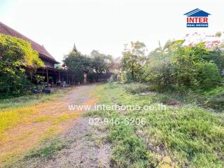 A spacious outdoor area with greenery and a traditional-style house