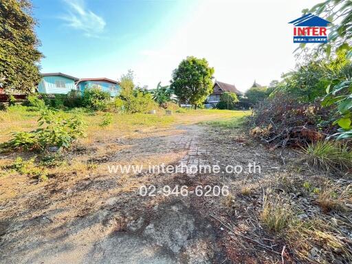 Vacant plot of land with some greenery and distant houses