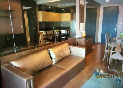 Modern living room with brown leather sofa and view of the dining area