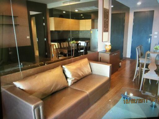 Modern living room with brown leather sofa and view of the dining area