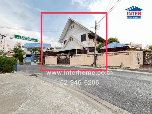 Street view of a large house with a slanted roof