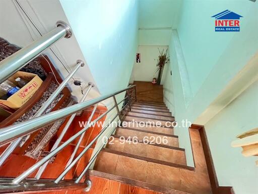 Interior staircase with metal railings and wooden steps