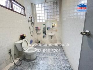 Spacious bathroom with a toilet, shower, and tile flooring