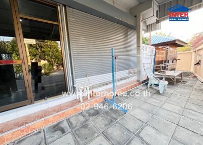 Outdoor seating area with tiled flooring and metal fencing