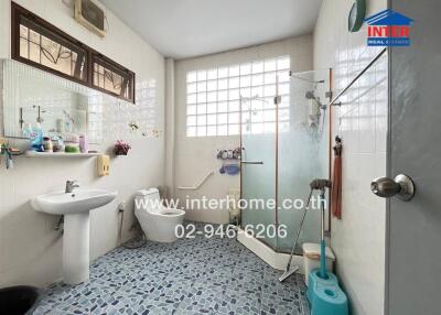 A well-appointed bathroom with a shower, toilet, sink, and various toiletries