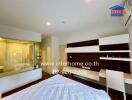 Modern bedroom with a large window, en-suite bathroom, desk area, and air conditioning