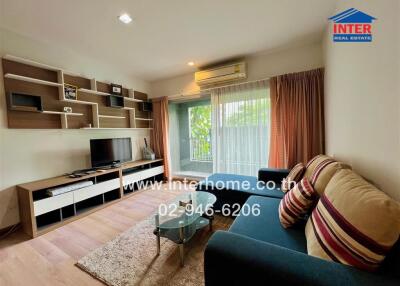 Modern living room with a large window, a TV, shelves, couch, and a rug