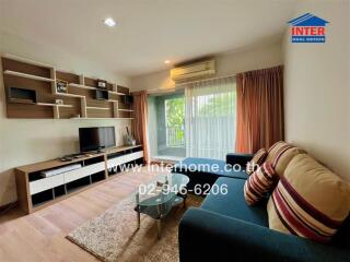 Modern living room with a large window, a TV, shelves, couch, and a rug