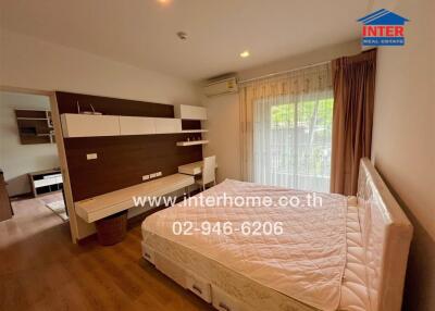 Spacious bedroom with large window and built-in storage