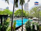 View of swimming pool with surrounding greenery in a high-rise residential area
