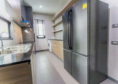 Modern kitchen with stainless steel refrigerator and dual sink