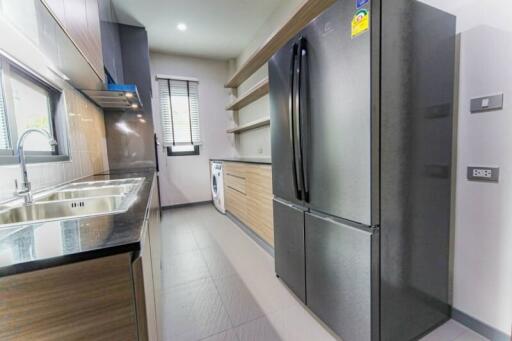 Modern kitchen with stainless steel refrigerator and dual sink