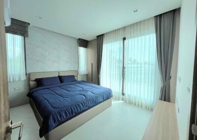 Modern bedroom with large windows and blue bedding
