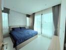 Modern bedroom with large windows and blue bedding