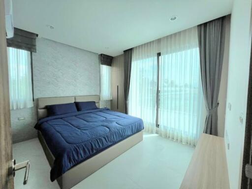 Modern bedroom with large windows and blue bedding