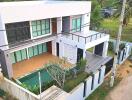 Modern two-story house with a pool and green surroundings