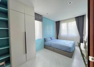 Modern bedroom with large windows and ample storage space