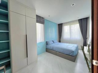 Modern bedroom with large windows and ample storage space