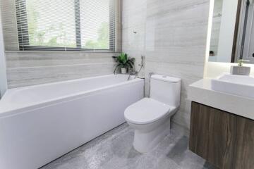 Modern bathroom with bathtub, toilet, and vanity