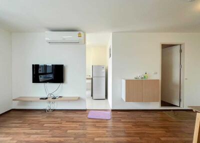 Modern living room with wooden flooring and wall-mounted TV
