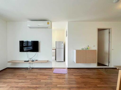 Modern living room with wooden flooring and wall-mounted TV