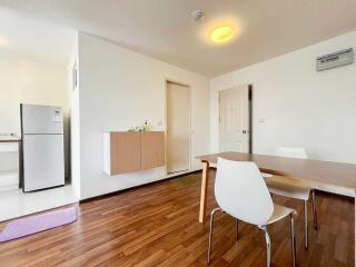 Modern dining area with a wooden table and white chairs