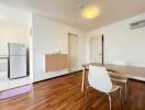 Modern dining area with a wooden table and white chairs