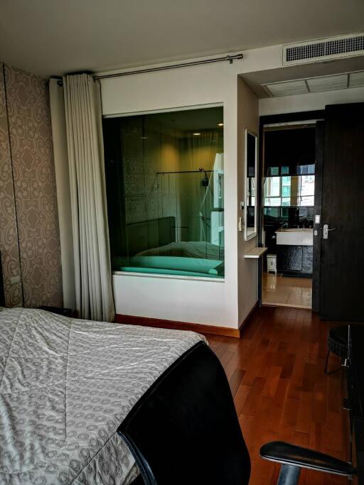 Modern bedroom with attached bathroom and glass partition