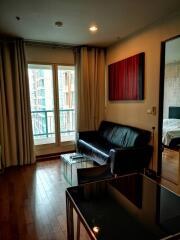 Modern living room with wooden flooring and balcony view